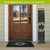 Welcome Wreaths Pine Reversible Porch Leaner, black and green design, leaning against house door entrance.