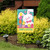 Easter Time Garden Flag with white bunny, chicks, and eggs on a colorful background outdoors.