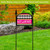 Neon Welcome sign on black stand with pink, black and white checkerboard acrylic design outdoor decor.