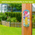 Butterflies and Peonies Metal Thermometer with colorful floral design and butterflies on a wooden post outdoors.