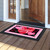 Black and pink Cupid's Hearts Doormat with Valentine's Day message on wooden porch outside doorway.