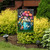 Garden Buddies Garden Flag with vibrant floral design featuring colorful tulips and butterflies on display outdoors.