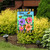 Busy Bees Garden Flag with colorful flowers, bees and "Bee Happy" text on a garden stand.