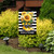 April Showers Garden Flag with welcome message, sunflowers, and yellow boots on black and white stripes.