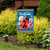 Ladybug Welcome Garden Flag with colorful flowers and "Welcome" text on a blue background displayed outdoors.