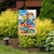 Beach Signs Garden Flag with colorful beach-themed design and phrases on a garden flag stand outdoors.