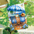 Beach Chairs House Flag with blue and white umbrella and striped chairs on a house exterior.