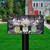 Lavender and Daisies floral design mailbox cover with butterflies on a black mailbox post outdoors.