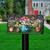 Garden Buddies Mailbox Cover with colorful floral design and butterflies on a black mailbox post outdoors.