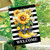 Yellow rain boots with sunflowers and daisies on black and white striped welcome house flag.