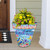 Large With God Planter with colorful flowers and birds design on front porch steps.