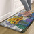 Rustic sunflowers comfort mat with colorful glass design under bare feet on wooden floor.
