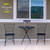 American Bloom Medium Planter on a small black metal table between two matching chairs outside.