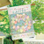 Pastel Easter Wreath House Flag with colorful eggs, bow, and Happy Easter text on wood background.