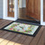 Hummingbird Wreath Doormat with colorful floral design and hummingbird on wooden porch at front entrance.