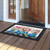 Blue Jar Bouquets doormat on wooden porch with colorful floral design and black border.