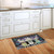 Lavender and Daisies floral doormat on wooden floor in front of white kitchen cabinets.