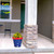 Star Spangled Medium Planter, blue ceramic pot with white stars and yellow flowers on a porch.
