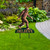 Brown Bigfoot metal art statue on green sign with orange Believe text on a lawn.