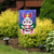 Happy Easter Bunny burlap garden flag with colorful bunny and crown on blue background outdoors.