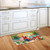 Happy Hour Parrot Doormat with colorful tropical design and palm leaves on wooden kitchen floor.