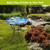 Dragonflies and Water Lilies Glass Birdbath on metal stand in garden with vibrant colorful design.