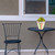 Spring Stripes Planter on a table with a chair, featuring pastel colors and white flowers.