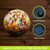 Rainbow speckled solar LED glass gazing ball with colorful mosaic pattern and solar panels.