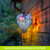 Colorful Hydrangeas Solar Balloon Lantern with floral design, glowing warmly against a wooden wall outdoors.