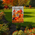 Thankful Gathering Garden Flag with colorful fall design and cardinals on a garden lawn display.