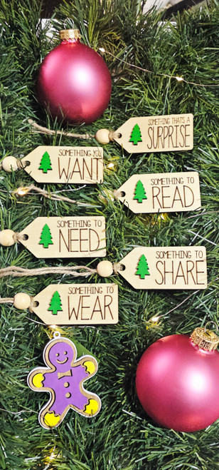 Set of six wooden Christmas gift tags with green tree cutouts, twine loops, and bead accents labeled Want, Need, Wear, Read, Surprise, and Share.