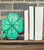 A kelly green, all wooden, laser-cut, laser engraved, four leaf clover being displayed as a book end.