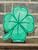 A kelly green, all wooden, laser-cut, laser engraved, four leaf clover table topper/book end.