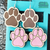 Handmade wooden paw print earrings in brown and pink with sterling silver hooks, lightweight pet lover jewelry