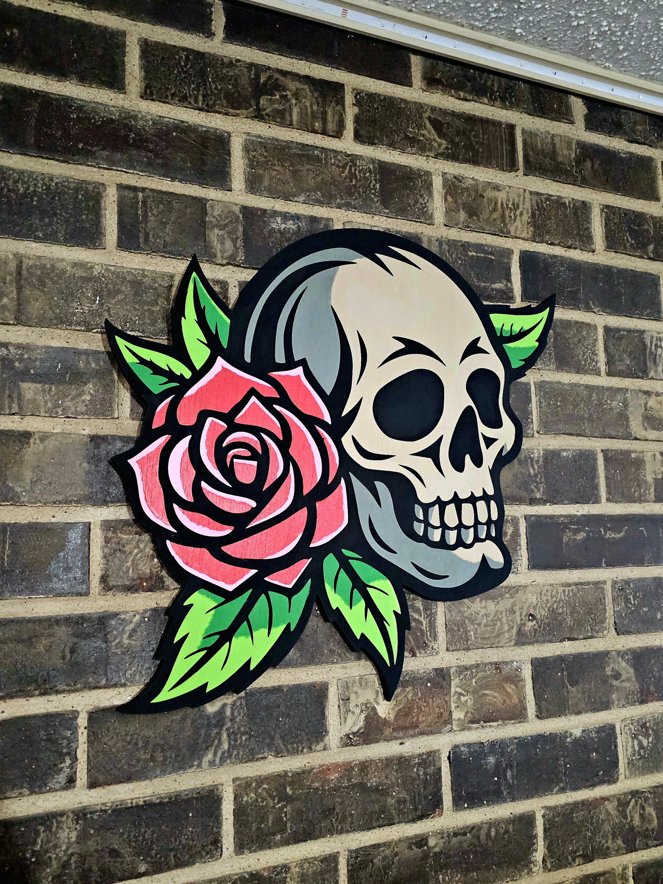 A memento mori skull with rose, laser cut with individual hand-painted pieces.
