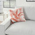 Banana Leaf Coral-Orange Reversible Outdoor Throw Pillow on sofa