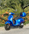 High-quality 2020 Vespa GTS 300 HPE in Matte Blu Vivace with color-matched top box, parked on a scenic California street.