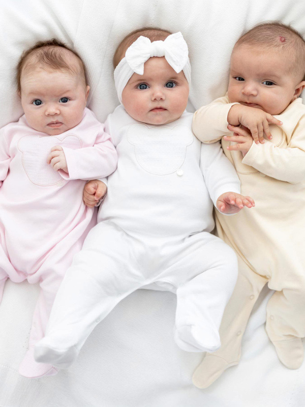 baby in romper smiling at the camera