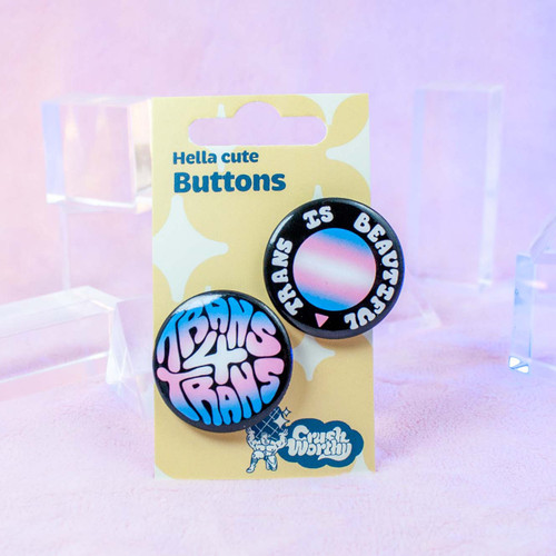 Trans 4 Trans & Trans is Beautiful button set by Crushworthy - Black background with the trans pride flag colors spelling out "Trans 4 Trans" in funky cute handwritten letters, with an accompanying white lettering "Trans is Beautiful" design around a trans pride flag colored gradient circle on metal pinbacks.