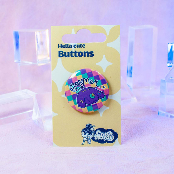 Gaymer Button by Crushworthy - A weirdly suggestive and but maybe kinda ergonomic controller on a rainbow background.