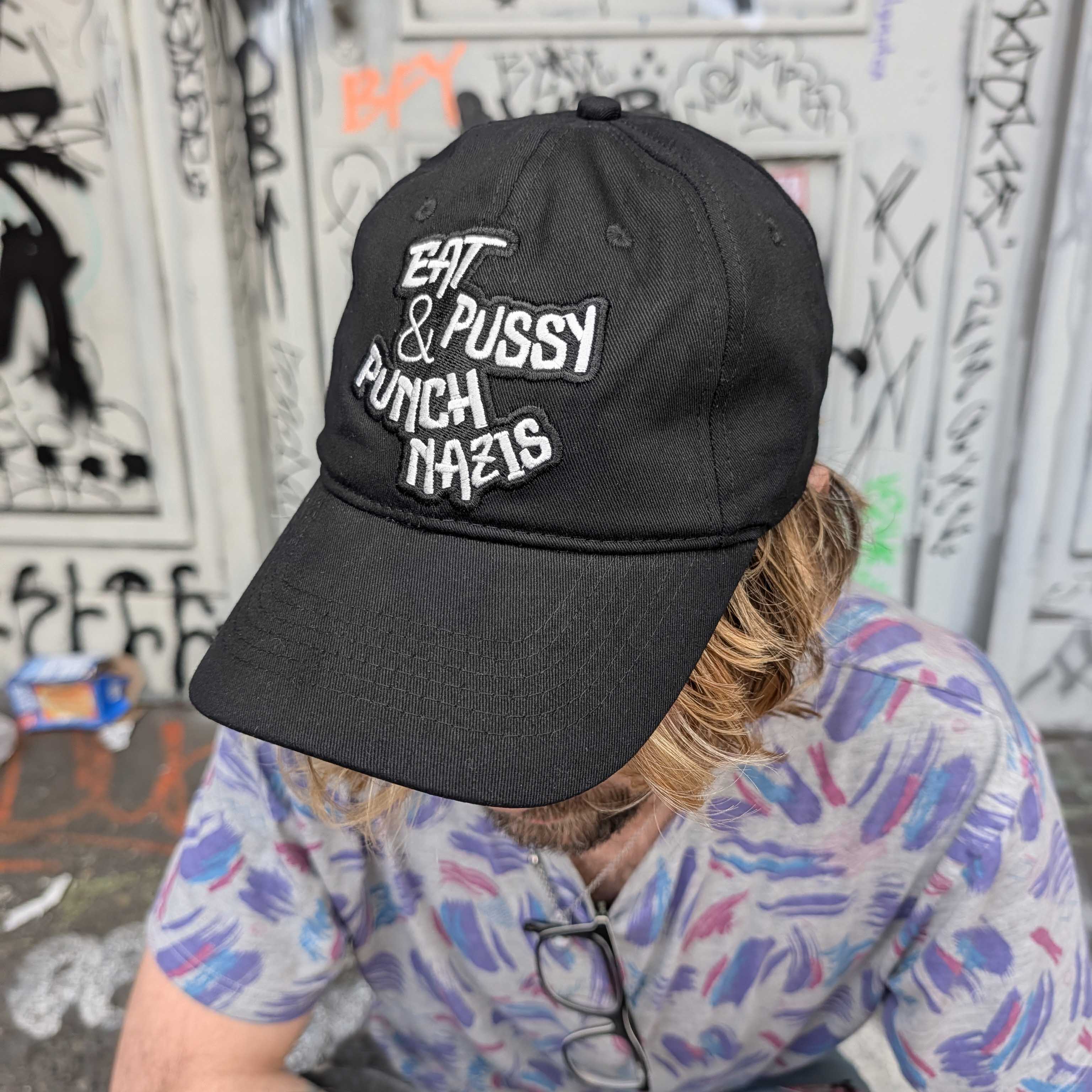 Eat Pussy & Punch Nazis Hat by Crushworthy – lesbian leftist black cap with white embroidery