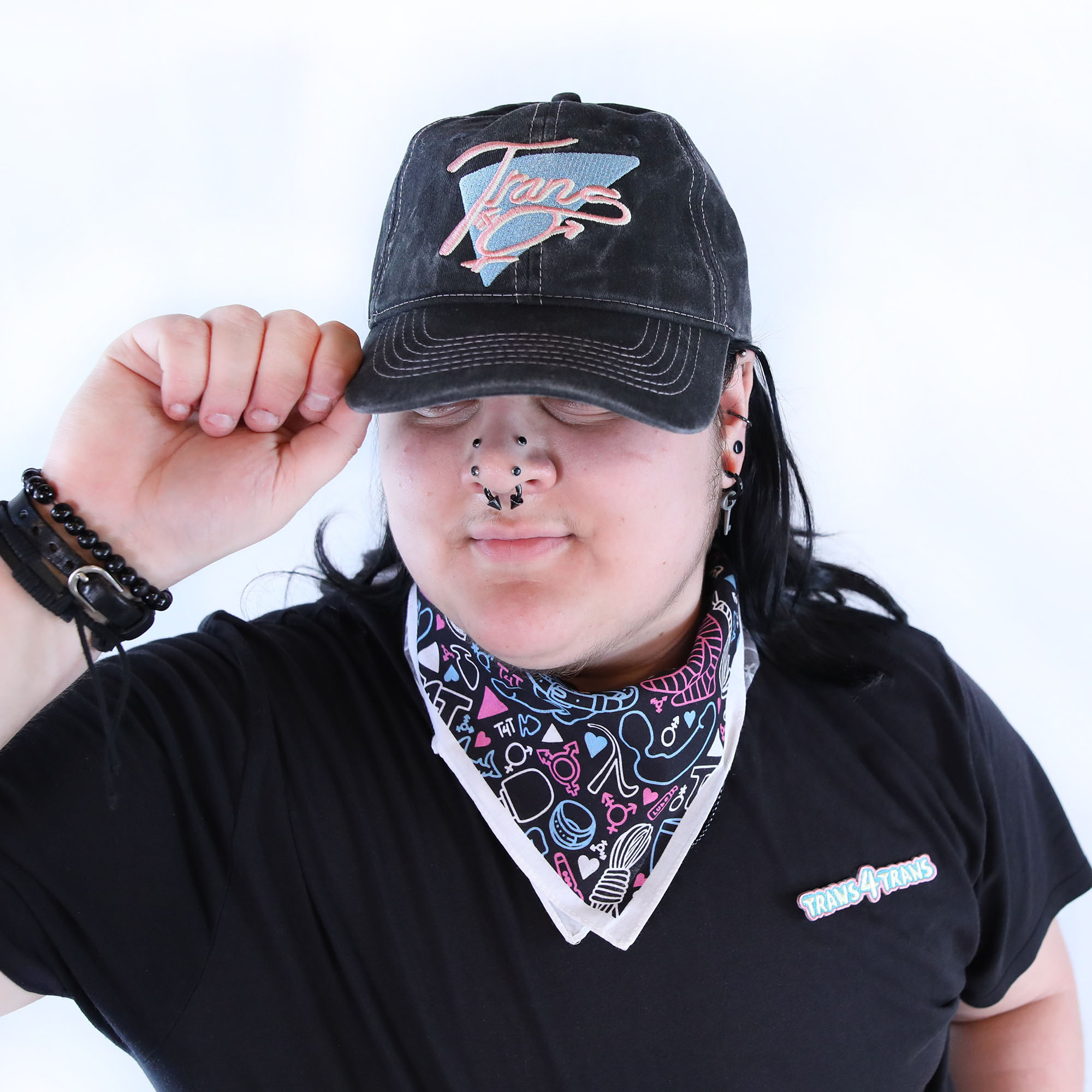 Trans Throwback Cap by Crushworthy - A fun retro embroidered design that says "Trans" with the trans symbol below it on an acid wash black baseball hat.