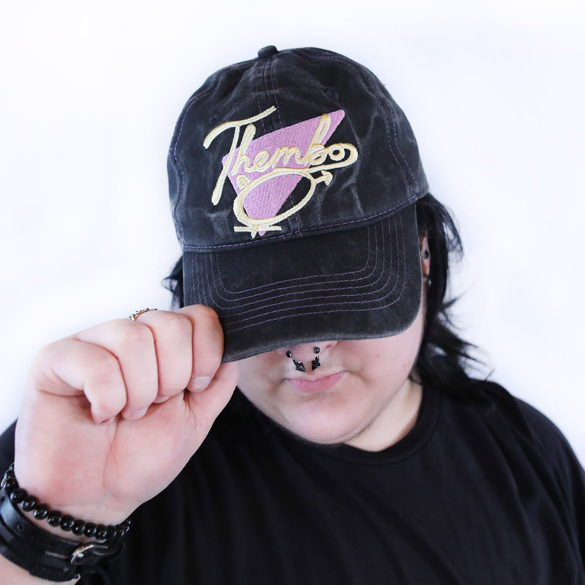 Thembo Throwback Cap by Crushworthy - Fun retro embroidery that says "Thembo" with a trans symbol below it, embroidered directly onto an acid wash black baseball cap.