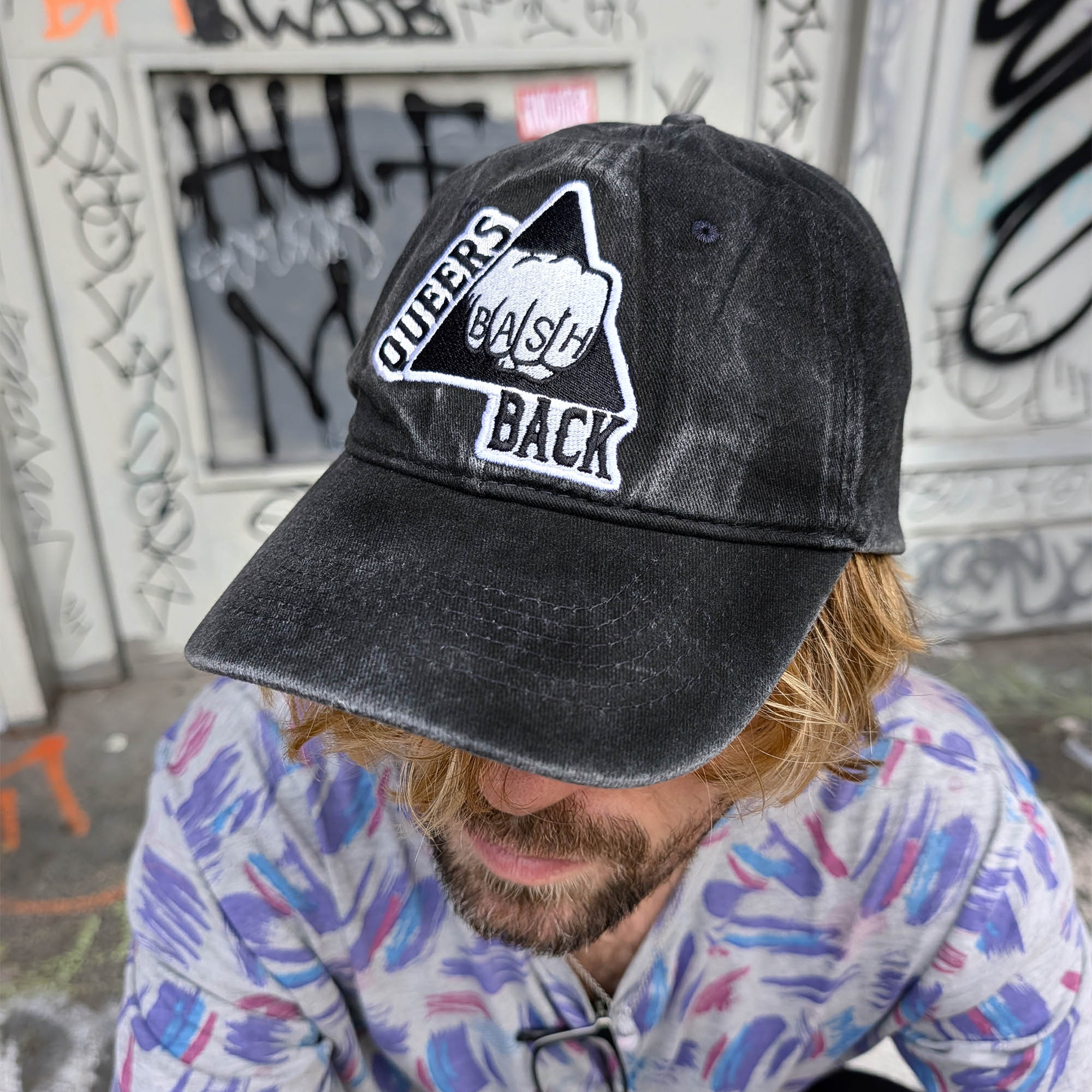 Queers Bash Back Cap by Crushworthy - Black and white embroidery that says "Queers Bash Back" with a fist on top of a triangle, embroidered directly onto an acid wash black baseball cap.
