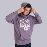 Posed view of the Pickleball Central Heritage Pickle-ball Groovy Front Logo Unisex Hoodie on a male model in the color Plum.