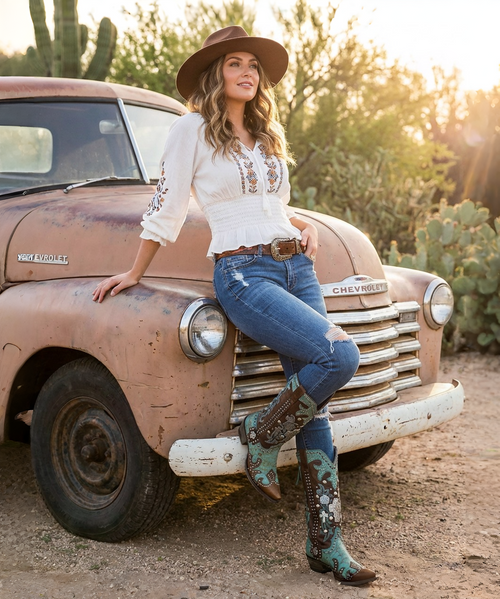 These boots are a bold, statement-making pair of western showstoppers that fuse classic cowboy craftsmanship with edgy, artistic detail ?✨

Crafted in a rich two-tone leather combination, the base features deep chocolate brown paired with a striking turquoise crackled finish that gives a vintage, worn-in character.

Key Design Features:
Intricate inlay and embroidery work in turquoise, creating flowing, western-inspired patterns along the shaft and vamp
Mixed metal embellishments, including studs, domed hardware, and decorative accents that add texture and dimension
Prominent cross appliqués and concho-style details, giving the boots a bold, southwestern, almost heirloom feel
A studded center seam running vertically up the shaft for added edge and structure
Subtle distressing throughout for that perfectly broken-in, authentic look
Silhouette & Structure:
Classic snip/pointed toe for a sharp, feminine western profile
Mid-height stacked heel that’s both flattering and wearable
Tall shaft designed to stand out whether paired with denim or dresses
Overall Vibe:

These boots blend rock-and-roll western attitude with artisan craftsmanship—perfect for someone who wants a standout, collectible piece. They feel equal parts vintage, rebellious, and luxurious, making them the kind of boots that instantly elevate any outfit