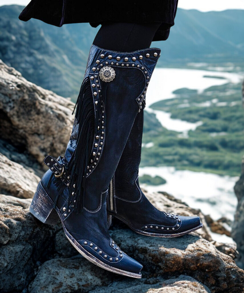 These boots make a statement so you don’t have to.
Double D Ranch’s Rusty Ravine Boot is the perfect cross-over boot – from runway to rodeo play - these kicks do the talking. Hand crafted in calfskin, and detailed with slotted conchos, nail heads and fringe – these collection boots draw their inspiration directly from the early vaqueros.  
Features:
Toe: Southern
Leather: brushed nubuck with calfskin contrast
Heel: tall fashion
Slotted conchos
Nail heads
Fringe
Buckled back strap These boots make a statement so you don’t have to.
Double D Ranch’s Rusty Ravine Boot is the perfect cross-over boot – from runway to rodeo play - these kicks do the talking. Hand crafted in calfskin, and detailed with slotted conchos, nail heads and fringe – these collection boots draw their inspiration directly from the early vaqueros.  
Features:
Toe: Southern
Leather: brushed nubuck with calfskin contrast
Heel: tall fashion
Slotted conchos
Nail heads
Fringe
Buckled back strap