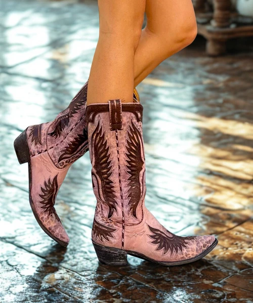 As distinctive and stylish as the king of rock and roll himself, the Elvis Pink Eagle boots by Old Gringo have been handcrafted for those cowgirls looking to make a bold statement! The distressed, rosy pink leather background is strategically accented with rustic brown leopard spots fit for the most daring of divas. The upper is flawless with two large, intricate cut out eagle designs, each etched out of rich brown leather, that rest over the front and back of the 13 inch shaft. Complimenting those designs are dark brown scalloped overlay designs at the top of the boot, complete with two loops for easy pull on. The boot vamp is just as stunning with matching eagle artwork that covers the heel as well as the sharp pointed toe. The boot is a fantastic mixture of soft suede, distressed leather, bold colors, and elaborate overlay designs. Girls, you’ll have the cowboys all shook up in your Elvis Pink Eagle boots by Old Gringo!

Measurements:

Shaft Height - 13"
Shaft Opening - 13.5" circum.
Heel Height - 9964 (Traditional)
Toe - 0 (Pointed)