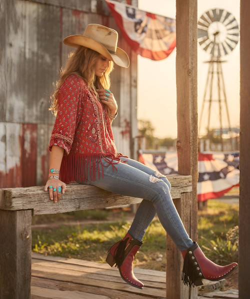 Step up your boot game with this season’s popular mid-calf length. Double D Ranch’s Apache Kid Boot adds a few more inches, a little more coverage, and a lot more style points.  Hand crafted in calfskin with contrast trim and sassy fringe, but it is the turquoise studded conchos that take this boot over the top.  

Features:

Toe: snip 

Leather: calfskin with suede contrast

Heel: tall riding 

Nail heads

Navajo style conchos

Self lacing and fringe