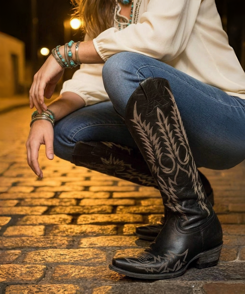 The Clint Boot by El Vaquero is a striking over-the-knee silhouette that blends refined craftsmanship with effortless summer elegance. Distinguished by a sleek ankle strap and beautifully detailed leather accents along the shaft, this boot delivers unmistakable style with a soft, artisanal feel.

Crafted in Italy from a unique combination of luxurious calfskin suede and fine natural linen, Clint offers a fresh, lightweight construction that’s perfect for warm-weather styling. The subtle 7 cm internal wedge provides comfortable lift without compromising ease, while the vintage treatment adds character and depth to every pair.

Finished with handcrafted stitching, nickel-free metal details, and a durable rubber sole, the Clint boot is designed for confident, all-day wear. Elegant yet relaxed, it pairs effortlessly with flowy dresses, tailored shorts, or layered summer looks.

Details:

Over-the-knee boot

Internal wedge: 7 cm

Vintage treatment

100% calfskin suede and natural linen

Handcrafted stitching

Nickel-free metal details

Rubber sole

Made in Italy